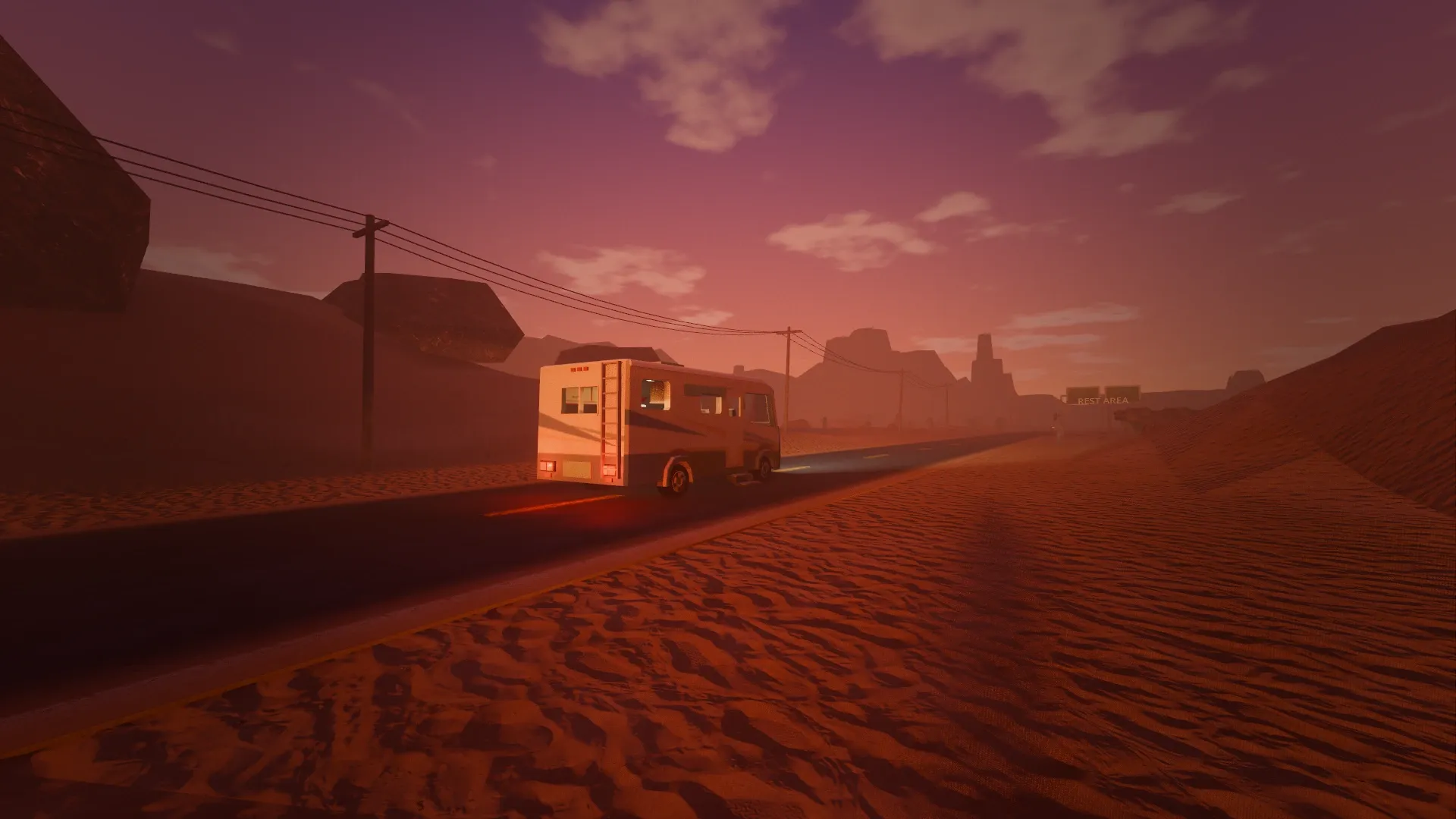 The camper on a desert highway at dusk, power lines and mesas on the horizon